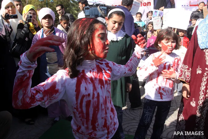 Palestinian children protest during a demonstration marking the 2nd anniversary of the Israel-Gaza war, in Gaza City on Monday, Dec. 27, 2010. Israel's volatile front with Gaza has been relatively quiet since the overwhe...