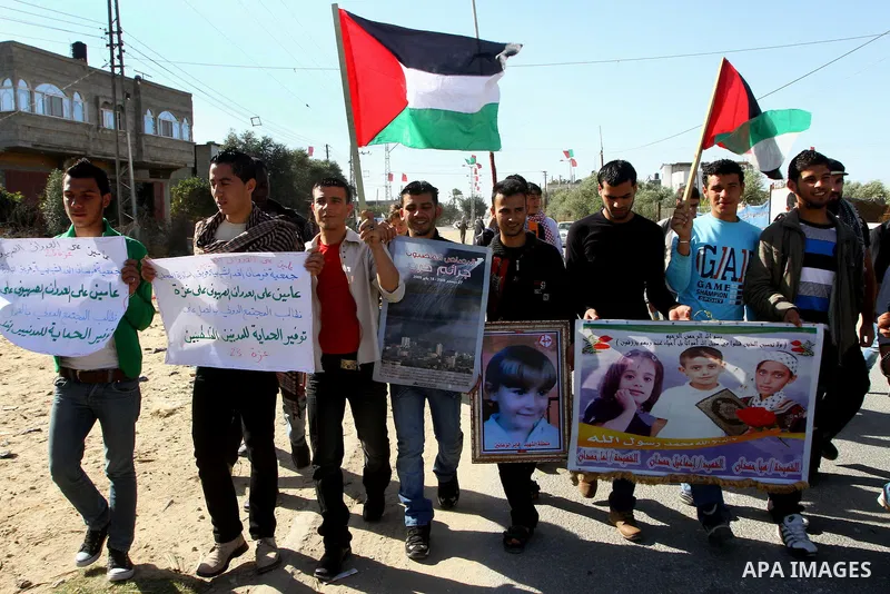 Palestinian protesters and foreign peace activists wave Palestinian national flags during a demonstration in front of the Erez crossing into Israel near the northern Gaza Strip town of Beit Hanun on December 28, 2010 to...