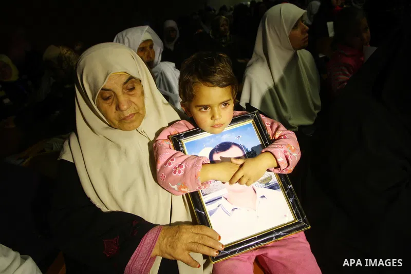 Palestinians hold pictures of their prisoned relatives in Israeli jails as they take part in a celebration in Gaza City, Dec. 28, 2010. About 7000 prisoners are in Israeli jails according to the Palestinian prisoners min...