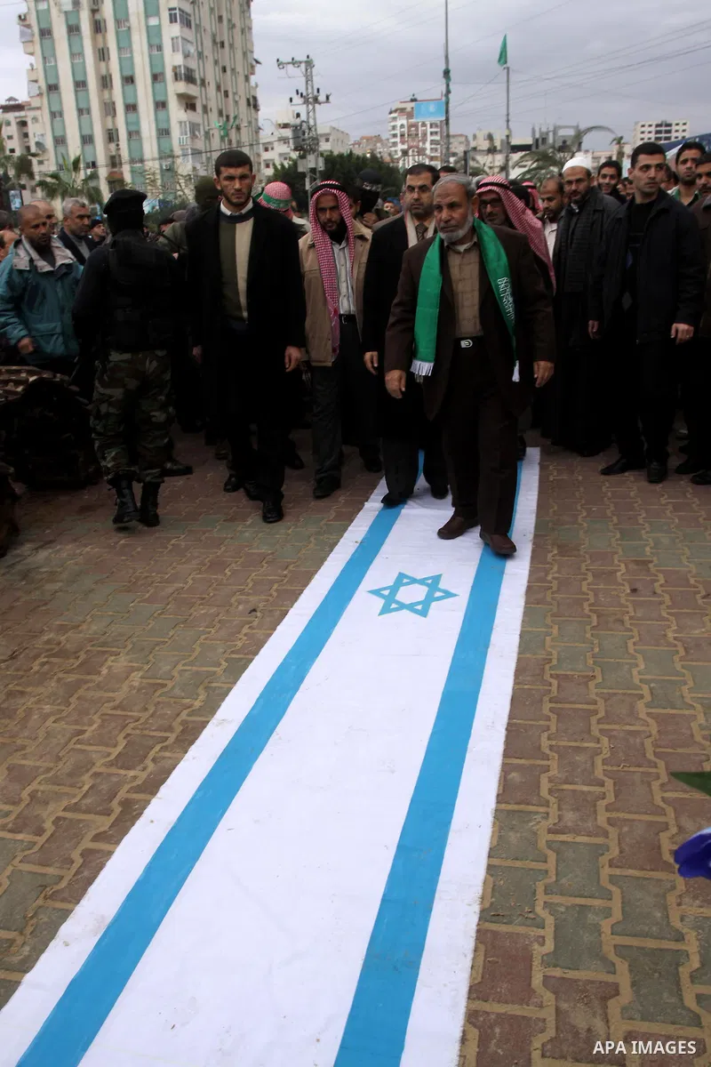A Palestinian Hamas leader, Mahmoud al-Zahar walks on an Israeli flag as part of a rally marking the 2nd anniversary of Israeli war on Gaza Strip, in Gaza City on January 1, 2011. Photo by Mohammed Asad