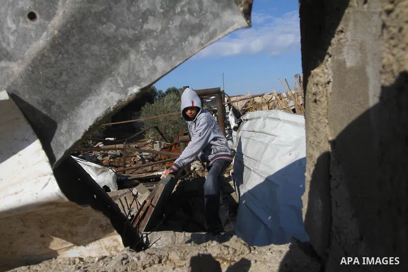 A Palestinian boy checks debris of houses destroyed during an Israeli air strike, near the Nuseirat refugee camp in central Gaza Strip on Jan. 2, 2011. Photo by Ashraf Amra