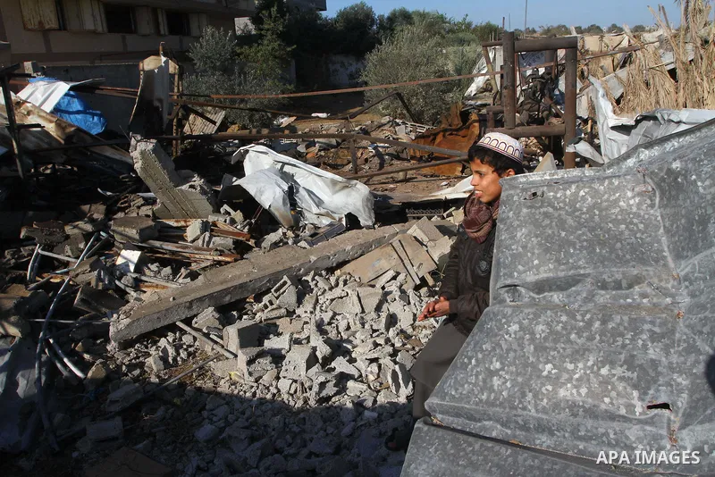 A Palestinian boy walks on debris of houses destroyed during an Israeli air strike, near the Nuseirat refugee camp in central Gaza Strip on Jan. 2, 2011. Photo by Ashraf Amra