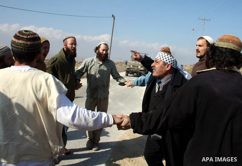A Palestinian man scuffles with Jewish settlers as he try to evacuate them from Palestinian land near the village of Yatta, south of the West Bank city of Hebron on Jan. 2, 2011. Photo by Najeh Hashlamoun