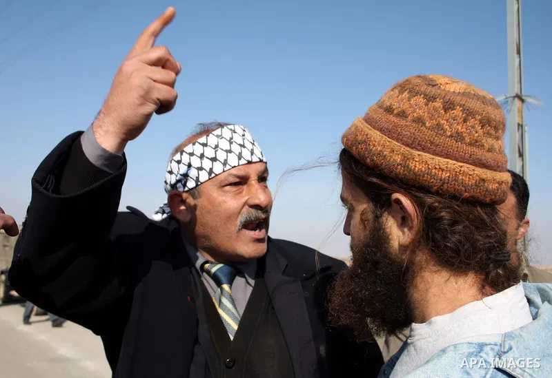 A Palestinian man scuffles with Jewish settlers as he try to evacuate them from Palestinian land near the village of Yatta, south of the West Bank city of Hebron on Jan. 2, 2011. Photo by Najeh Hashlamoun