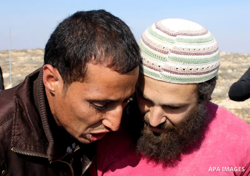A Palestinian man scuffles with Jewish settlers as he try to evacuate them from Palestinian land near the village of Yatta, south of the West Bank city of Hebron on Jan. 2, 2011. Photo by Najeh Hashlamoun