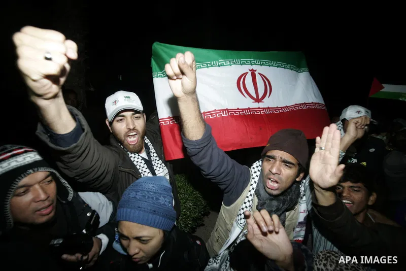 Pro-Palestinian activists hold the Iranian flag as they recieve a cheering welcome by Palestinians upon the arrival of the "Asia 1" convoy to the Gaza Strip through Rafah border crossing between Egypt and southern Gaza S...