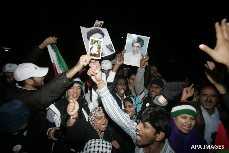 Pro-Palestinian activists hold the Iranian flag as they recieve a cheering welcome by Palestinians upon the arrival of the "Asia 1" convoy to the Gaza Strip through Rafah border crossing between Egypt and southern Gaza S...