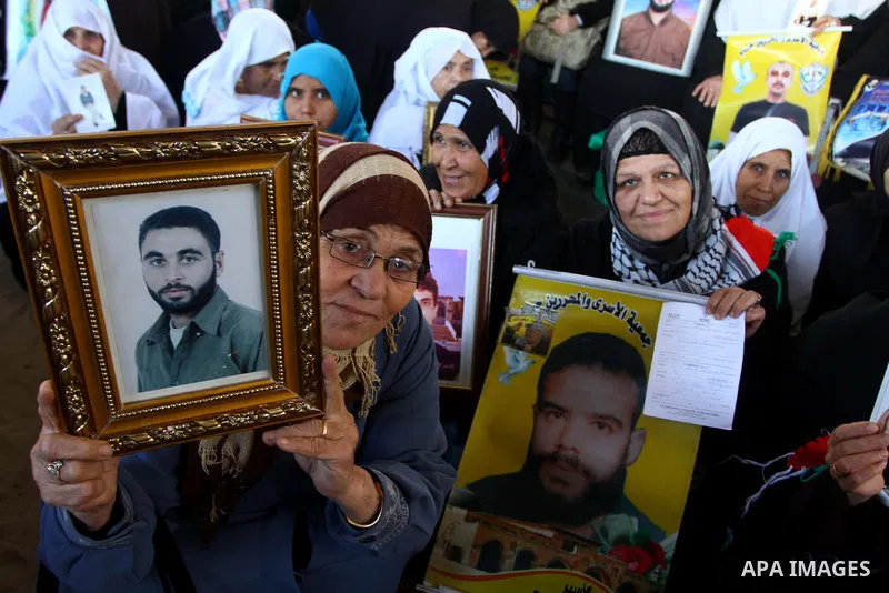 Palestinian women hold pictures of jailed relatives during a protest calling for the release of Palestinian prisoners from Israeli jails at the Red Cross office in Gaza City on Jan. 3,2011. Photo by Ashraf Amra