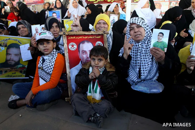 Palestinian women hold pictures of jailed relatives during a protest calling for the release of Palestinian prisoners from Israeli jails at the Red Cross office in Gaza City on Jan. 3,2011. Photo by Ashraf Amra