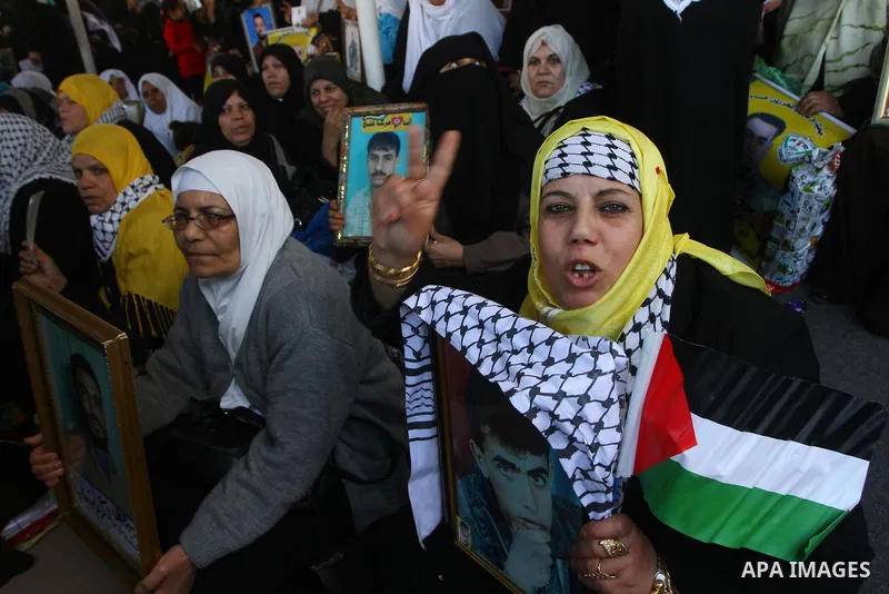 Palestinian women hold pictures of jailed relatives during a protest calling for the release of Palestinian prisoners from Israeli jails at the Red Cross office in Gaza City on Jan. 3,2011. Photo by Ashraf Amra