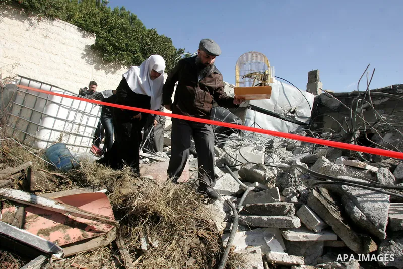 Palestinians from the Siam family walk on the rubble of their house in the Sheikh Jarrah neighbourhood of East Jerusalem January 3, 2011 after it was destroyed earlier in the day by Israeli municipality bulldozers for al...