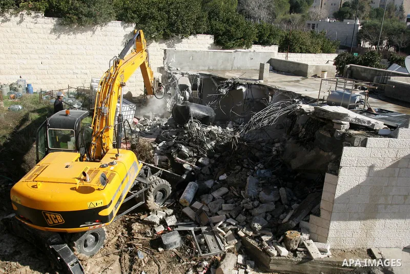 An Israeli bulldozer destroys a Palestinian house in the Sheikh Jarrah neighbourhood of East Jerusalem January 3, 2011. The house was destroyed by Israeli municipality bulldozers for allegedly being built without a permi...