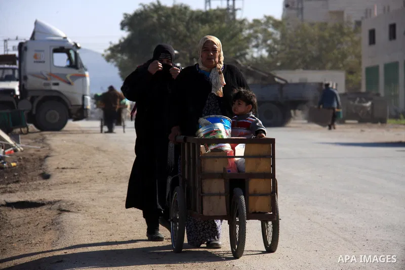 A Palestinian woman pushes his grandson standing on a cart along a street in the West Bank refugee camp of Balata, near Nablus, Monday,Jan. 3, 2011. Photo by Wagdi Eshtayah