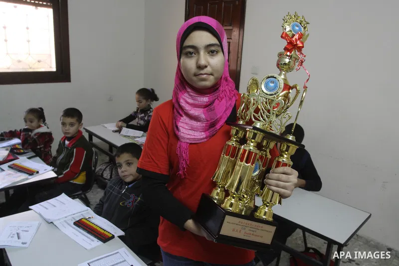 A Palestinian schoolgirl, Meyer-Tai, 14, carries her award at her school for Intelligent Mental-Arithmetic , in Gaza City on Jan. 3,2010. Meyer-Tai, has won the fourth place in the world competition Intelligent Mental-Ar...