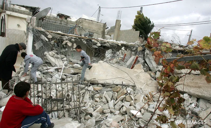Palestinians stand on the rubble of a home after Israeli army bulldozers destroyed the house in the Arab neighborhood of Beit Hanina in occupied east Jerusalem on on Jan. 4, 2011. Photo by Mahfouz Abu Turk