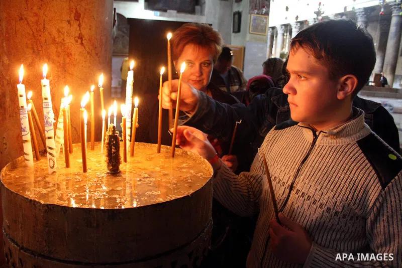 A worshipper lights a candle in the Church of the Nativity, traditionally accepted as the birthplace of Jesus Christ, in the West Bank city of Bethlehem on January 05, 2011. Photo by Najeh Hashlamoun