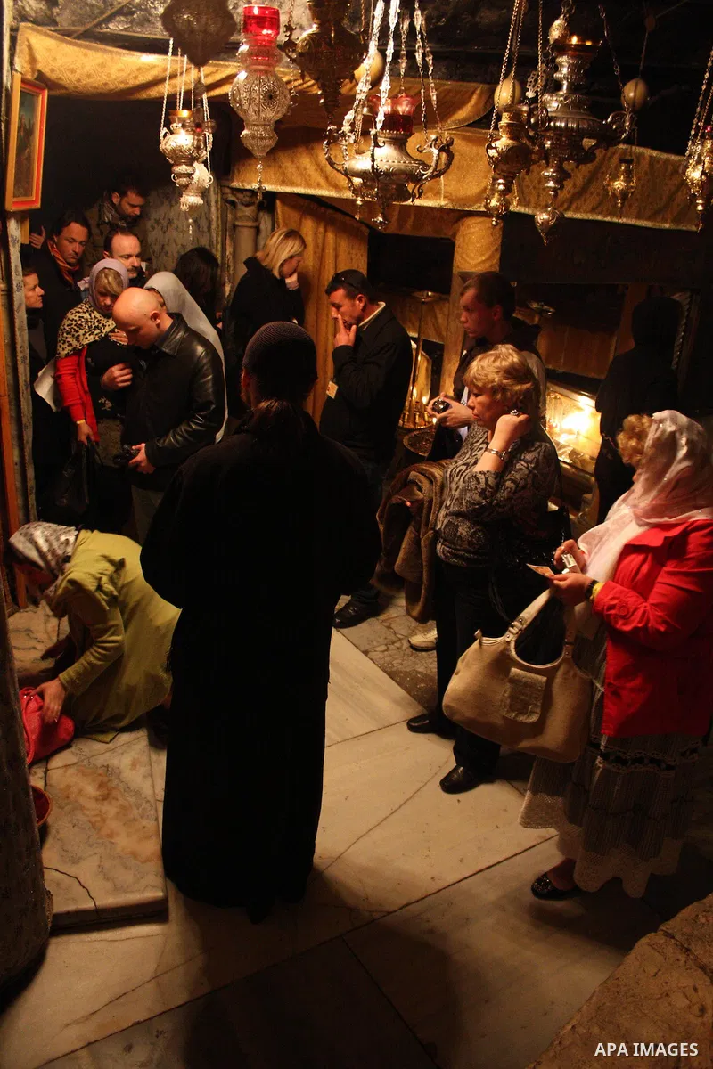 Christian worshippers take part in a prayer in the 'Grotto,' or cave in the Church of the Nativity, traditionally accepted as the birthplace of Jesus Christ, in the West Bank city of Bethlehem on January 05, 2011. Photo...