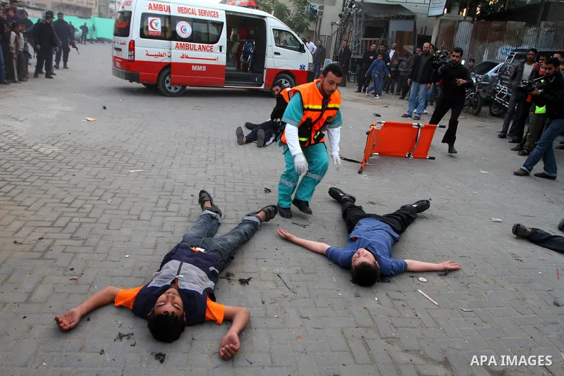 Palestinian youths act as mock injured as they take part in a rally organised by Hamas marking the second anniversary of the Israel-Gaza war in the Jabalia refugee camp in the northern Gaza Strip on January 6, 2011. Phot...