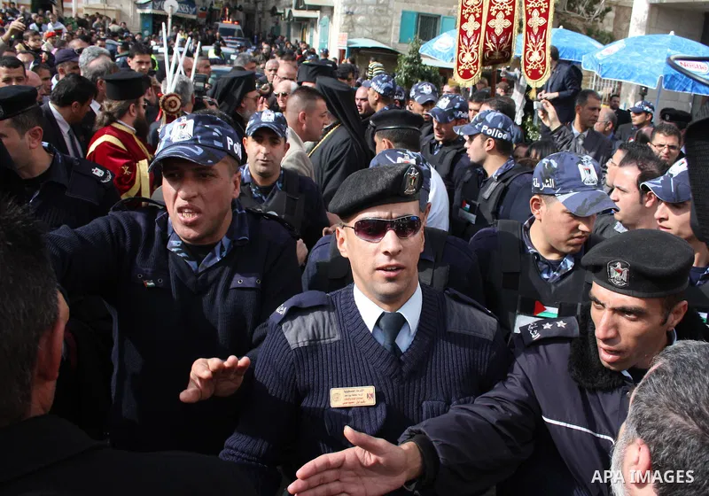 Palestinian police stand guard as Patriarch Theophilos III of Jerusalem blesses pilgrims during a Orthodox Christmas procession outside the Church of the Nativity, where Christians believe the Virgin Mary gave birth to J...