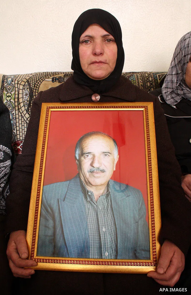 The wife of 67-year-old Omar Kawasme holds his picture she said he was killed by Israeli troops on January 7, 2010 in Hebron during a raid to arrest suspected militants. The shooting happened early in the morning as sold...