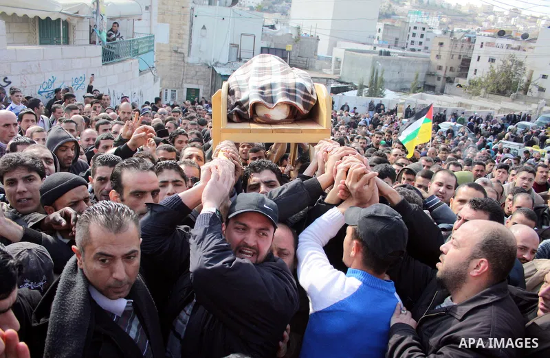 Palestinian mourners carry the body of Omar Qawasma a 67-year-old after he shot dead by Israeli troops and in Hebron on January 7, 2010. The Palestinian man was shot dead by Israeli soldiers during a raid in the West Ban...
