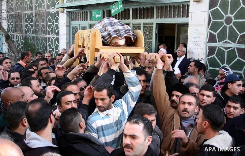 Palestinian mourners carry the body of Omar Qawasma a 67-year-old after he shot dead by Israeli troops and in Hebron on January 7, 2010. The Palestinian man was shot dead by Israeli soldiers during a raid in the West Ban...