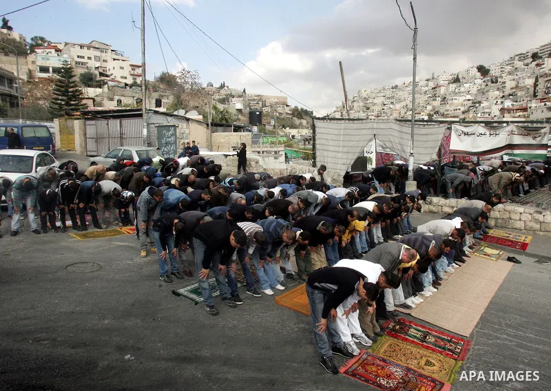 Palestinian Muslim worshipper attend Friday prayers near a protest tent in the mostly Arab neighbourhood of Silwan in east Jerusalem on Jan 7, 2011. Photo by Mahfouz Abu Turk