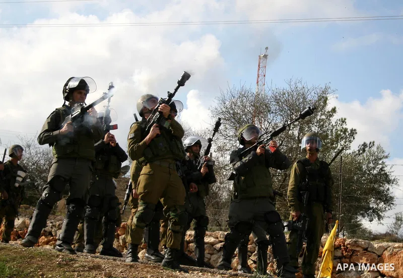 Isareli soldiers fire tear-gas grenades at protesters in the village of Bilin on January 7, 2011. Israeli troops in Hebron shot dead an elderly Palestinian civilian on Friday in a case of mistaken identity as they search...