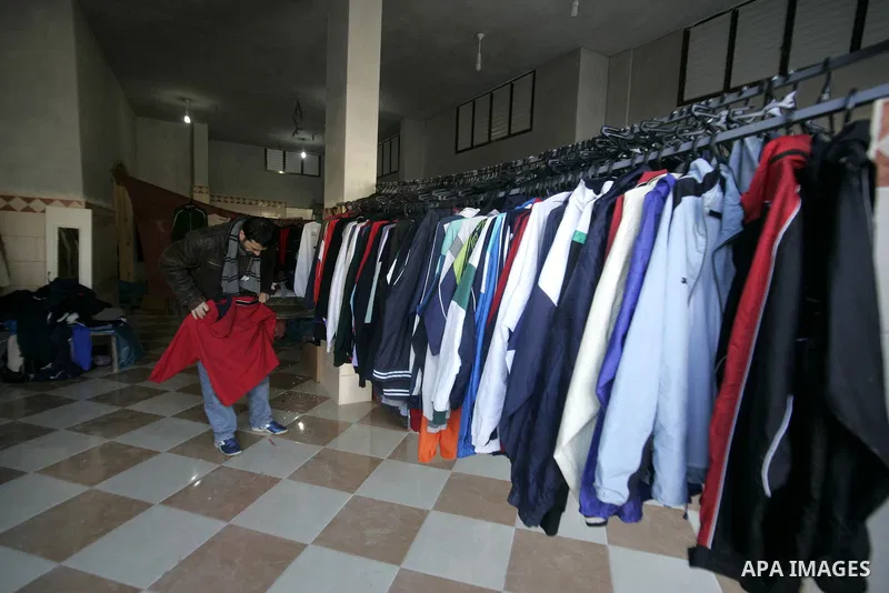 A Palestinian man searches for suitable clothes from a second-hand clothes at a shop in Rafah, southern Gaza Strip on January 08, 2011. Palestinians flock to buy used clothes known as (bale) that come from European count...