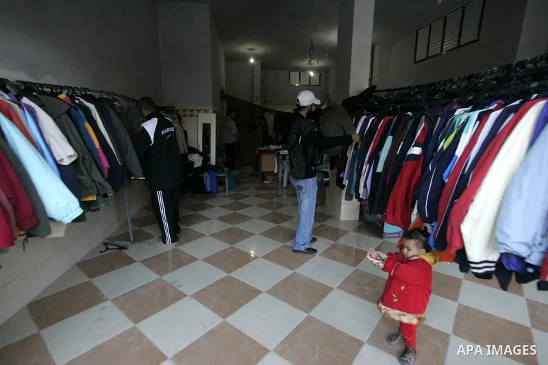 A Palestinian man searches for suitable clothes from a second-hand clothes at a shop in Rafah, southern Gaza Strip on January 08, 2011. Palestinians flock to buy used clothes known as (bale) that come from European count...