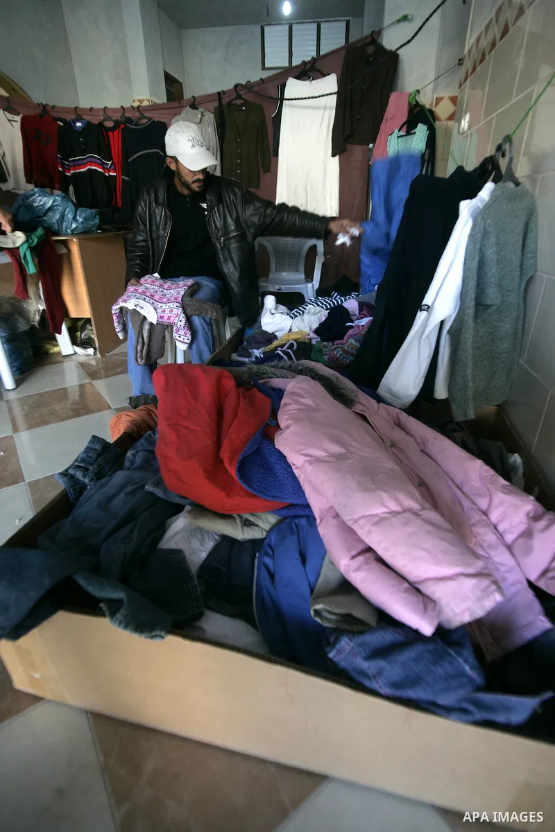 A Palestinian man searches for suitable clothes from a second-hand clothes at a shop in Rafah, southern Gaza Strip on January 08, 2011. Palestinians flock to buy used clothes known as (bale) that come from European count...