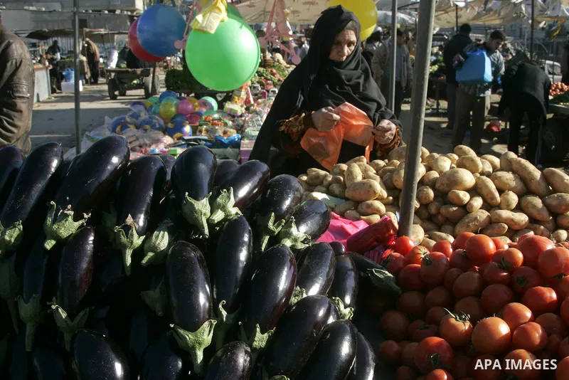 A Palestinian woman buys vegetable at a market in southern Gaza town of Rafah on January 10, 2011. Photo by Abed Rahim Khatib