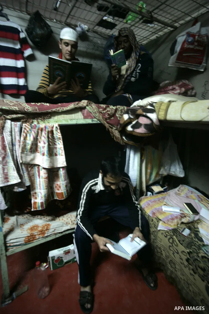 Palestinian inmates read Holy Quran inside a cell at a prison controlled by the Hamas police in the southern Gaza Strip town of Khan Younis on Jan. 9, 2011. According to Hamas police, number of prisoners accused of spyin...