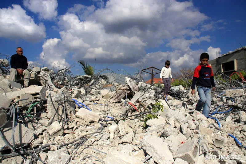 Palestinian Samer Younis family walk on the rubble of her house after Israeli troops demolished the house that was built without a construction permit in the West Bank village of Azzun Atma, near Qalqilia, Tuesday on Jan...