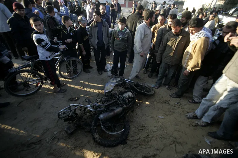 Palestinians inspect a motorcycle that was ridden by Mohamed al-Najjar and targeted during an Israeli air strike in Khan Yunis in the southern Gaza Strip on January 11, 2011. Al-Najjar was killed in the strike. Photo by...