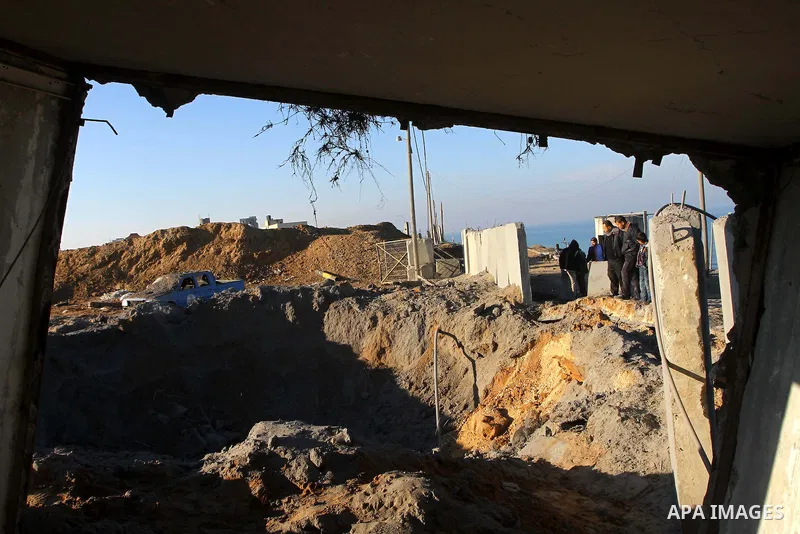 Palestinians survey the damage after an Israeli air strike on a Hamas security compound in al-Nuseirat refugee camp in the central Gaza Strip January 12, 2011. Security officials said three air strikes took place around...