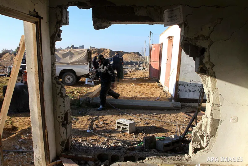 Palestinian Hamas police officers survey the damage after an Israeli air strike on a Hamas security compound in al-Nuseirat refugee camp in the central Gaza Strip January 12, 2011. Security officials said three air strik...