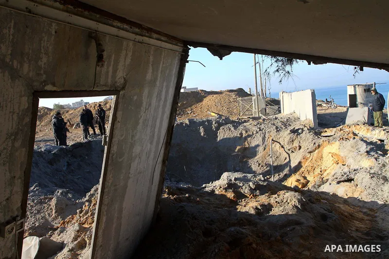 Palestinian Hamas police officers survey the damage after an Israeli air strike on a Hamas security compound in al-Nuseirat refugee camp in the central Gaza Strip January 12, 2011. Security officials said three air strik...