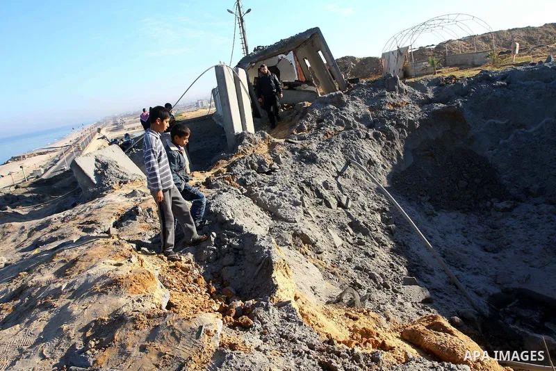 Palestinian boys look at the damage after an Israeli air strike on a Hamas security compound in al-Nuseirat refugee camp in the central Gaza Strip January 12, 2011. Security officials said three air strikes took place ar...