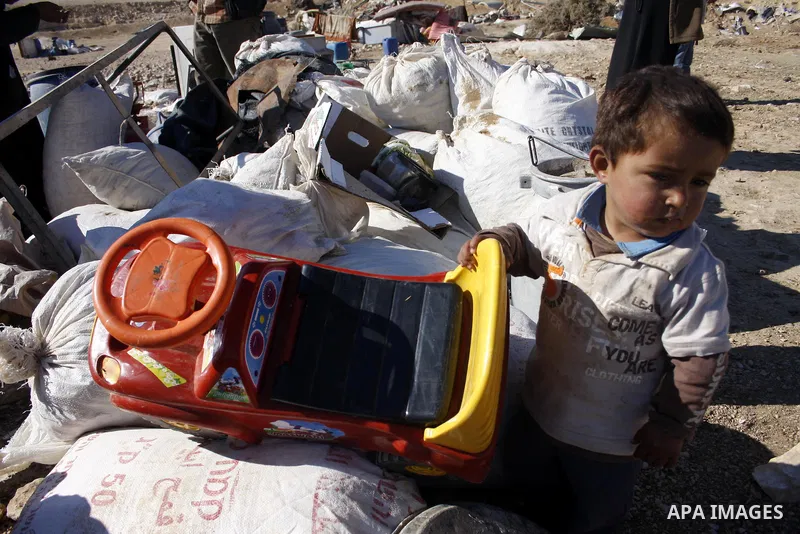 Palestinians bedouin sit on their belongings as Israeli bulldozers demolish their house in the West Bank village of Yatta near Hebron on Jan. 12, 2011. Israeli Army pulled down Wednesday an elementary school and 17 homes...