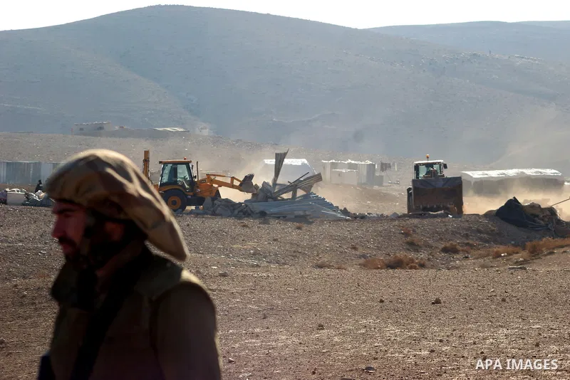 Israeli bulldozers demolish their house in the West Bank village of Yatta near Hebron on Jan. 12, 2011. Israeli Army pulled down Wednesday an elementary school and 17 homes lodging about 300 Bedouin persons near Hebron....