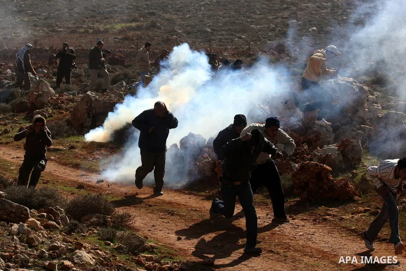 Israeli soldiers use tear gas to disperse Palestinians during a clash between Jewish settlers and Palestinians over farming land between the Jewish settlement Shiloh and the West Bank the village of Qusrah near Nablus, T...