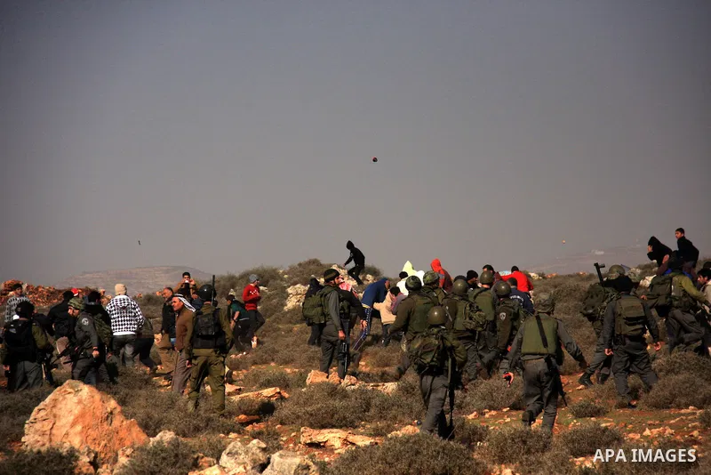 Israeli soldiers use tear gas to disperse Palestinians during a clash between Jewish settlers and Palestinians over farming land between the Jewish settlement Shiloh and the West Bank the village of Qusrah near Nablus, T...