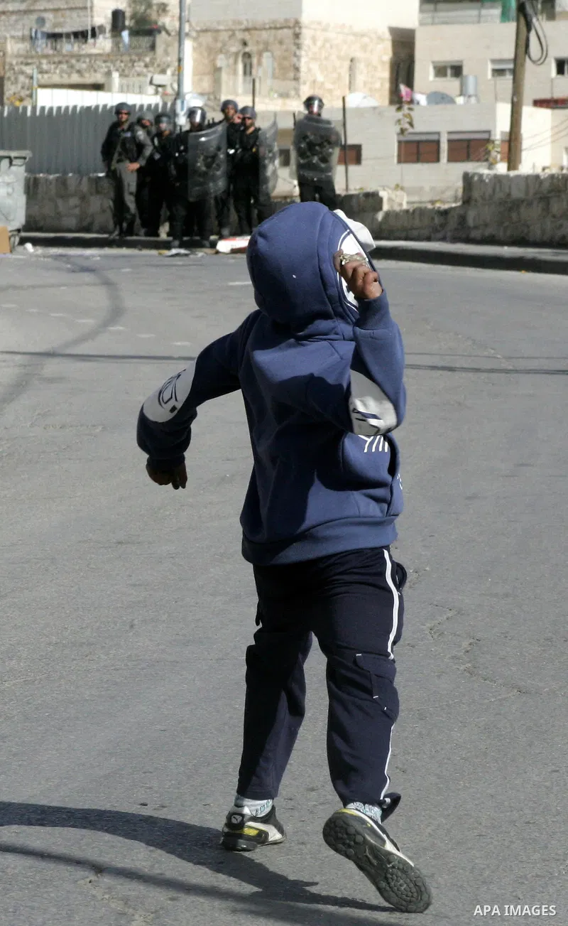 Palestinian youths hurl stones towards Israeli soldiers during clashes in the Arab east Jerusalem neighbourhood of Silwan against Jewish settlement activity in the Palestinian districts of the holy city on Jan. 14, 2011....
