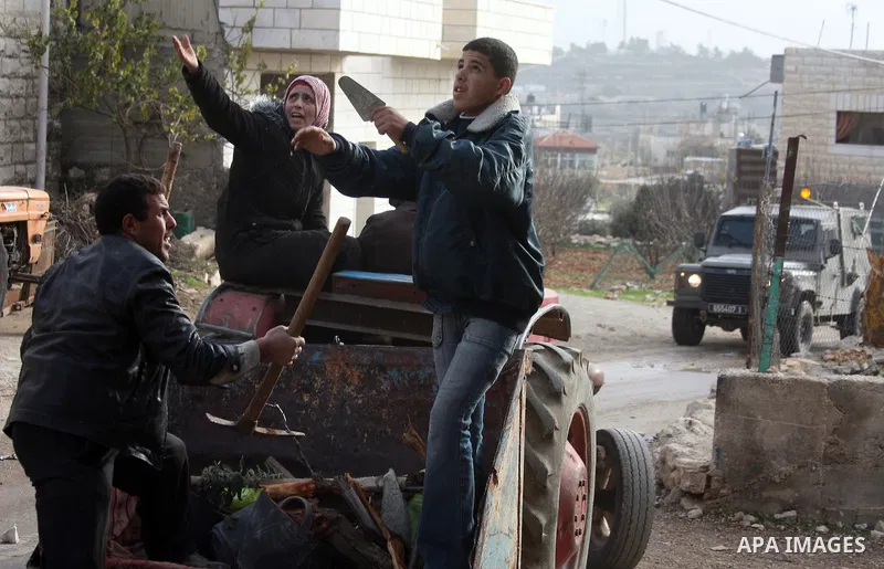 Palestinians scuffle with Israeli soldiers during a demonstration against the Israeli controversial separation barrier in the West Bank village of Beit Ommar near Hebron on January 14, 2011. Reports state that Israel say...