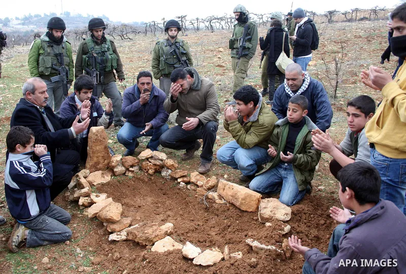 Israeli soldiers stand guard during a demonstration by Palestinian, Israeli and foreign activists against the demolishing of farm land to be used in the construction of Jewish settlements near the existing Israeli settle...