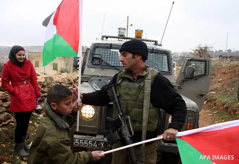 Israeli soldiers stand guard during a demonstration by Palestinian, Israeli and foreign activists against the demolishing of farm land to be used in the construction of Jewish settlements near the existing Israeli settle...