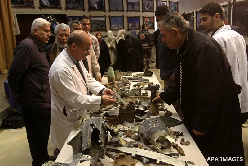 Palestinians look at the remains of the ammunition which was used during the war on Gaza at an exhibition organized by Palestinian High Commission marks the second anniversary of Israel's three-week offensive on Gaza, at...