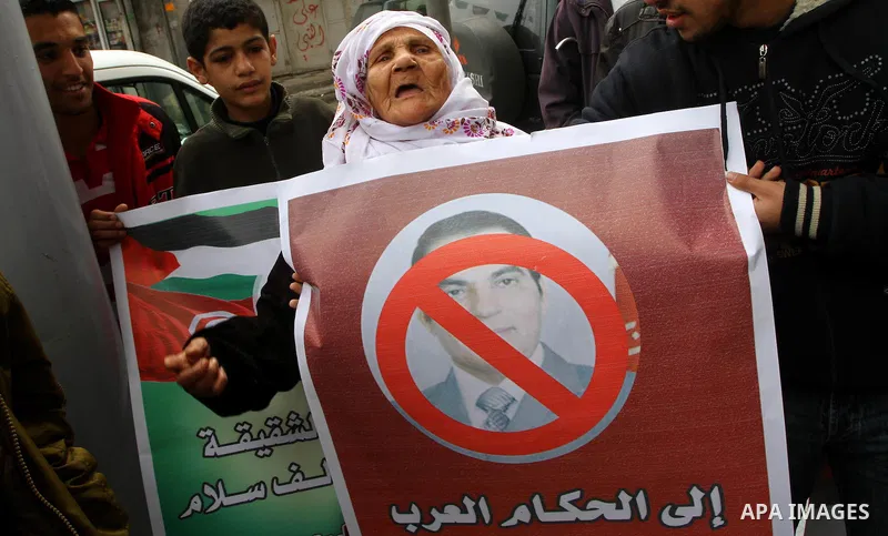 A Palestinian holds a poster with a picture of Tunisia's former President Zine al-Abidine Ben Ali during a Hamas rally in Gaza City to show support for the Tunisian people on January 16, 2011. Tunisia's new leadership mo...