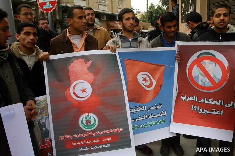 Palestinians hold posters during a Hamas rally in Gaza City to show support for the Tunisian people on January 16, 2011. Tunisia's new leadership moved to form a coalition government to gain the upper hand over violent l...